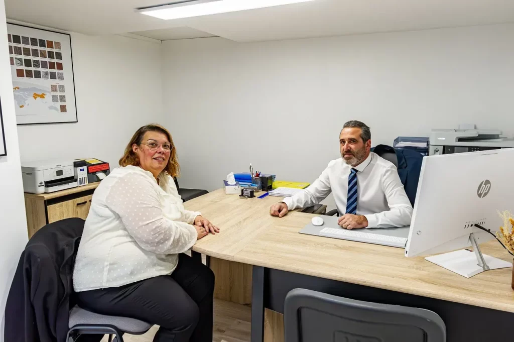 Conseiller funéraire recevant une cliente en entretien dans un bureau privé.